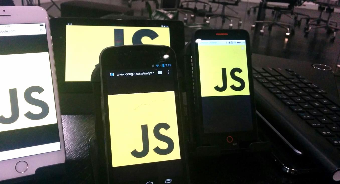 Photo of phones on a desk with JavaScript logo on them